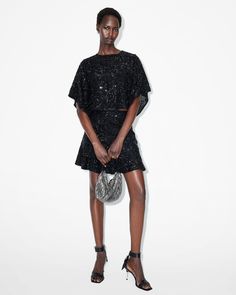 Sparkle all season long. The Ivy Top has a flowing shape that boasts a round neck and delicately draped sleeves. It's relaxed-fitting and cropped to create an elevated structure. Elegant gems, sequins and bead embellishments are a luxe touch. Dress this up with the matching skirt or fitted pants (don't forget a statement metallic heel, now that's a look).  This top is designed to a relaxed fit Keyhole button closure at the back of the neck Round neck Short sleeves Cropped Draped sleeves and heml Embellished Crop Top, Draped Sleeves, Fitted Pants, Drape Sleeves, Metallic Heels, The Ivy, Embellished Top, Fitted Trousers, Going Out Outfits