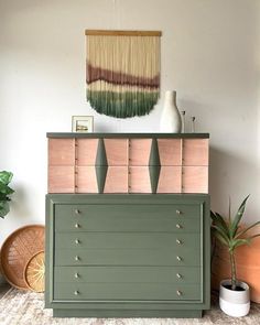 the dresser is painted green, pink and brown