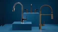 two faucets and a sink in a blue room