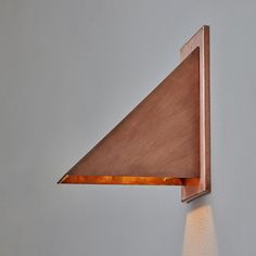 a light that is on the side of a wall with a triangle shaped object in it