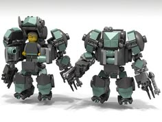 two green and gray robots standing next to each other