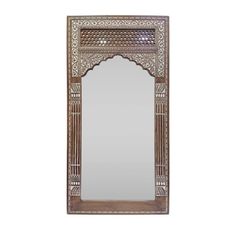 an ornate wooden mirror hanging on the wall