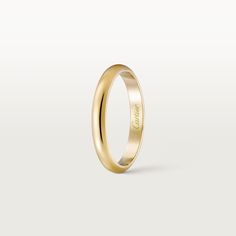 a yellow gold wedding ring with the word love engraved on it's side, in front of a white background