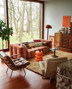 a living room filled with furniture next to a large glass window covered in lots of windows