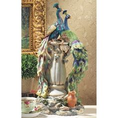 two peacocks sitting on top of a vase next to a pot and saucer