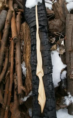 an odd looking piece of wood sitting on top of snow covered ground next to tree branches