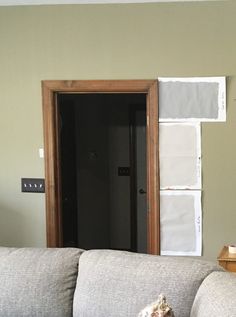 a living room filled with furniture and paint samples on the wall next to an open door