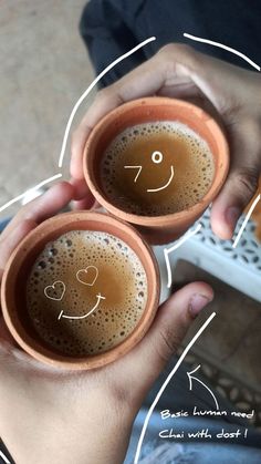 two people holding coffee cups with faces drawn on them