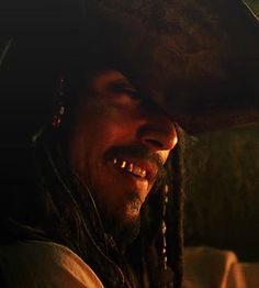 a close up of a person wearing a hat with dreadlocks on his head