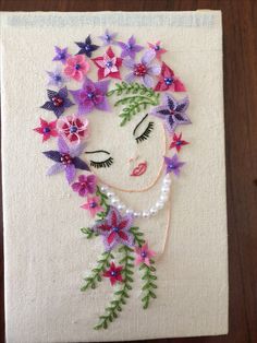 a woman with flowers in her hair on a piece of cloth that has been embroidered onto it