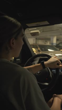 a man and woman sitting in the driver's seat of a car with their hands on the steering wheel