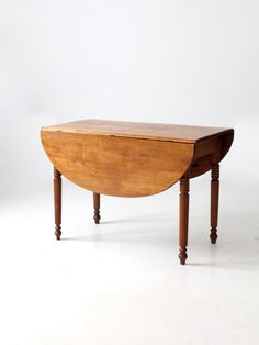 an old wooden table with two legs and a curved top, on a white background