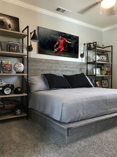 a bedroom with a bed, shelves and soccer balls on the wall above it's headboard