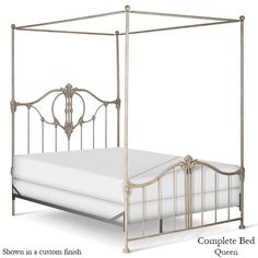 an antique style metal bed frame with white sheets and headboard, shown from the front