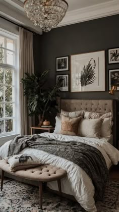 a bedroom with a bed, chandelier and pictures on the wall above it