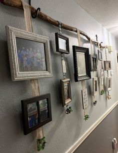 a group of framed pictures hanging on the side of a wall next to a hallway