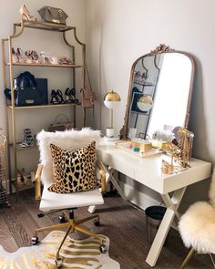 a white desk with a mirror, chair and leopard print pillow in front of it