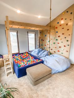 an indoor play area with climbing walls and balls on the floor, in a house