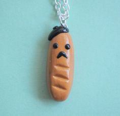 a hot dog with a mustache on it's face is hanging from a chain