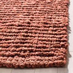 a close up of a rug on the floor with wood floors and white walls in the background