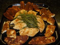 some chicken and green beans on a black plate