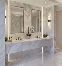 a marble bathroom with two sinks and mirrors