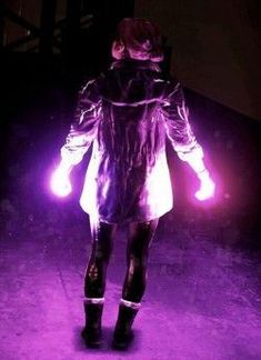 a woman in black and white is walking down the street with bright lights on her hands