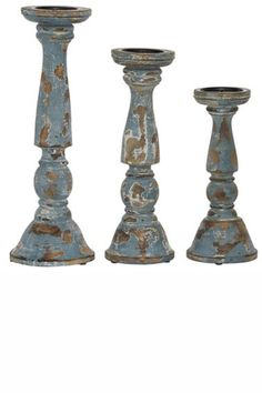 three tall blue candlesticks sitting next to each other