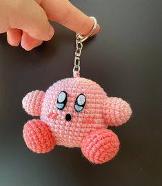 a pink crocheted keychain with an elephant on it's face