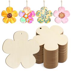 wooden flower cutouts and paper flowers hanging from clothes pegs on a white background