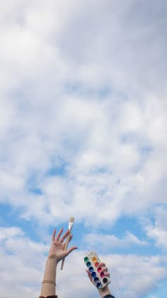 two people reaching up to catch a frisbee in the air with their hands