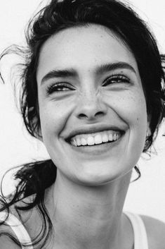 a black and white photo of a woman smiling