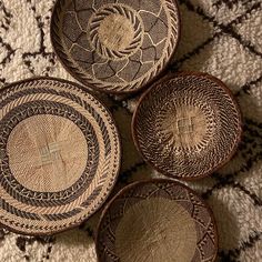 three woven baskets sitting on top of a rug