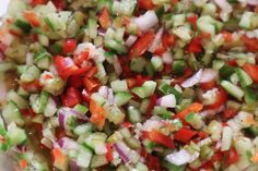 a bowl filled with chopped up vegetables and seasoning sitting on top of a table