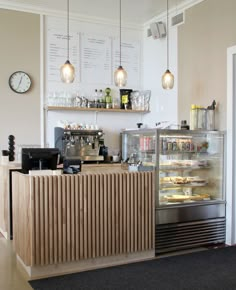 a bakery with lots of food and drinks on the counter, along with hanging lights