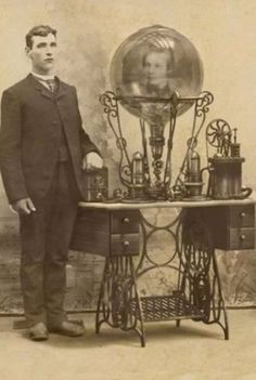 an old photo of a man standing next to a table