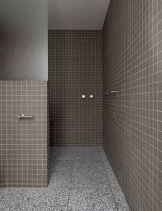 a tiled bathroom with two urinals on the wall