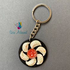 a keychain with some food on it and a red sauce in the middle