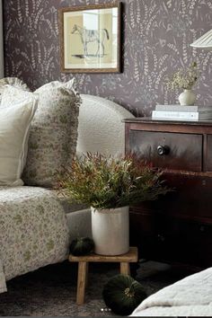 a living room filled with furniture and a lamp on top of a wooden table next to a bed