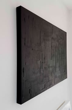 a black piece of art hanging on the wall