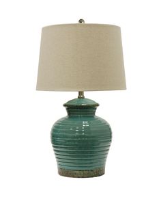 a green lamp with a beige shade on it