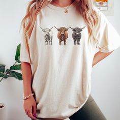 Western Shirt, Highland Cows Shirt, Comfort Colors, Cow Lover Shirt, Funny Cow Shirt, Farm Lover Shirts, Farm Animal Shirt,  If you're looking for a thick, structured tee that's also super soft and breathable--look no further! The men's garment-dyed heavyweight t-shirt ticks all the boxes and is made of 100% ring-spun cotton. The regular t-shirt style will complement most looks and fit you to a tee. * 100% ring-spun cotton * Fabric weight: 6.1 oz/yd² (206.8 g/m²) * Garment-dyed * Relaxed fit * 7/8″ double-needle topstitched collar * Twill-taped neck and shoulders for extra durability * Double-needle armhole, sleeve, and bottom hems * Blank product sourced from Honduras This product is made especially for you as soon as you place an order, which is why it takes us a bit longer to deliver it Highland Cow Shirts Vinyl, Highland Cow Shirt, Cute Short Sleeve Cow Print T-shirt, Cheap Casual Cow Print T-shirt, Cow Print Cotton Short Sleeve T-shirt, Cow Shirt, Cows Funny, Animal Tshirt, Western Shirts