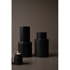 two black candles sitting next to each other on a table