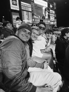 black and white photo of men sitting on bench at baseball game