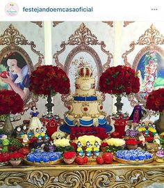 the table is decorated with red flowers and cakes