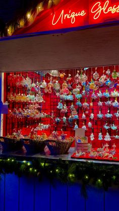 a christmas display in front of a store with lights and decorations on the outside wall