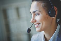 a woman wearing a headset smiling and looking to the side with her eyes closed