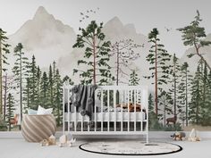 a white crib in front of a forest mural