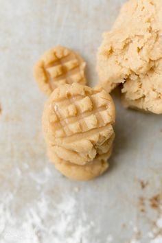 two pieces of peanut butter cookies sitting on top of a white countertop next to each other