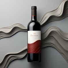 a bottle of red wine sitting on top of a table next to a wall decoration